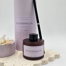 Load image into Gallery viewer, Luxury reed diffuser home fragrance in 100ml amber glass bottle with black reeds. Presented in lilac cylinder box ready for gifting. Fragrance Watermelon.
