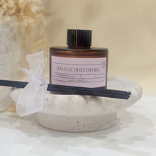 Load image into Gallery viewer, A diffuser with a bottle and sticks on a textured surface
